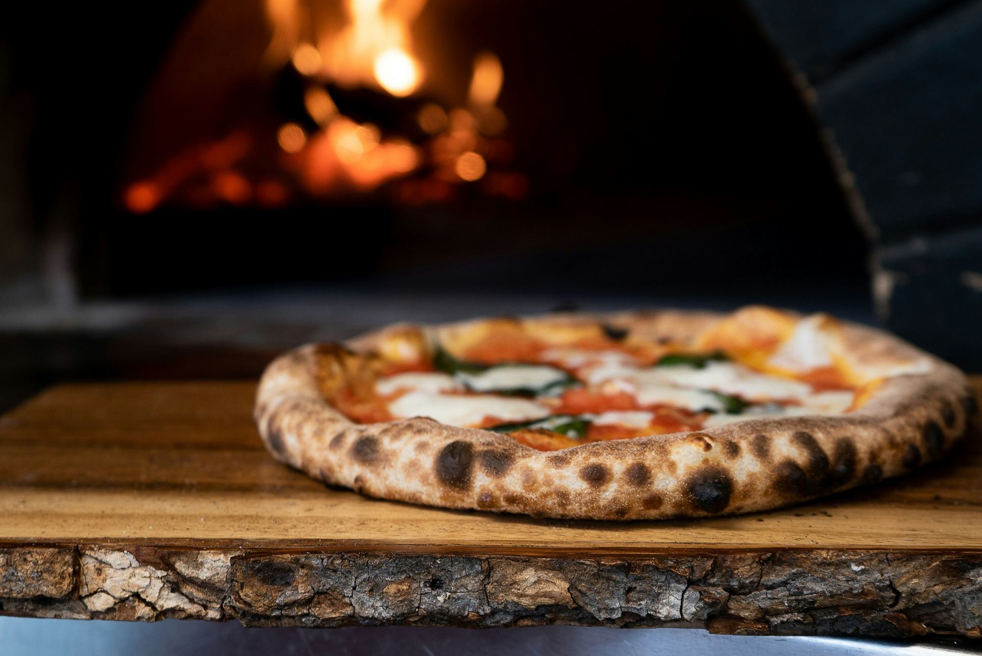 Pizza sortant du four à bois